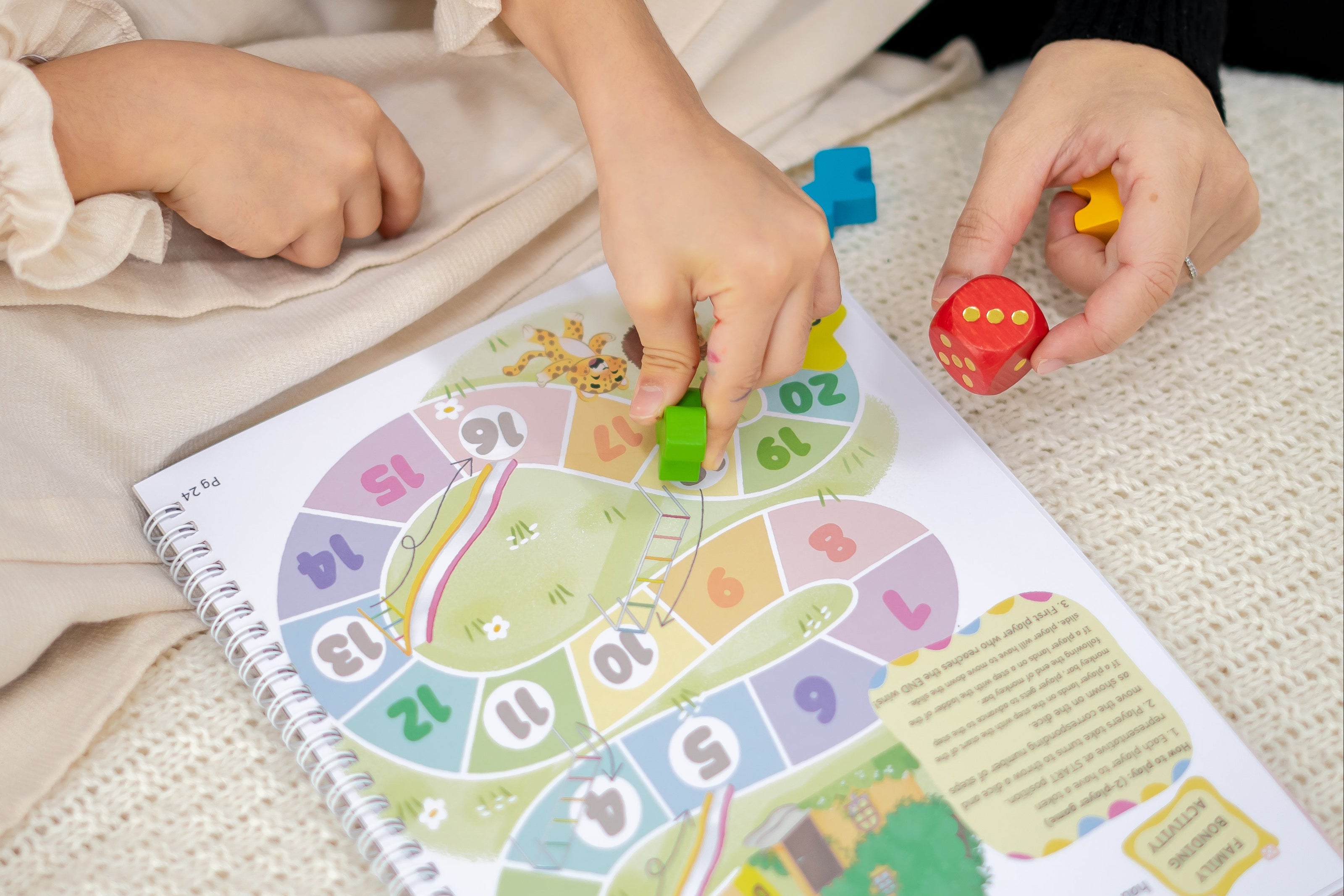Child playing with a colorful board game on a light surface